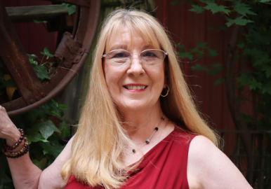 Susan smiling outdoors, reflecting her mission of healing and connection
